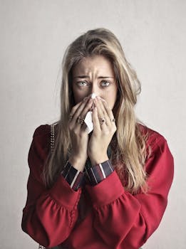 Portrait of a woman sneezing with a tissue, depicting flu symptoms.